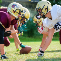 two football teams facing each other at scrimmage line