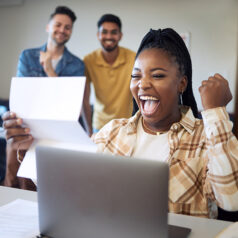 Female celebrating news on letter she is reading